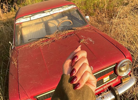 Close-up of a woman’s hands with wine-red nail polish for an easy winter nail.