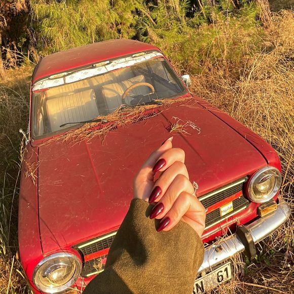 Close-up of a woman’s hands with wine-red nail polish for an easy winter nail.