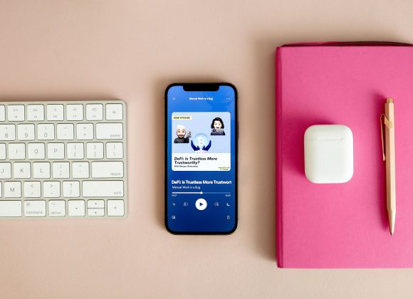Smartphone playing one of the best motivational podcasts on a minimalist desk setup, creating a calm and inspiring atmosphere for mindful listening.