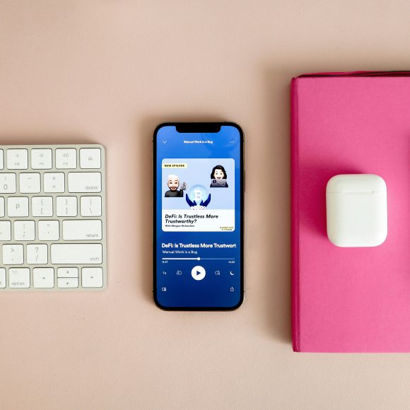 Smartphone playing one of the best motivational podcasts on a minimalist desk setup, creating a calm and inspiring atmosphere for mindful listening.