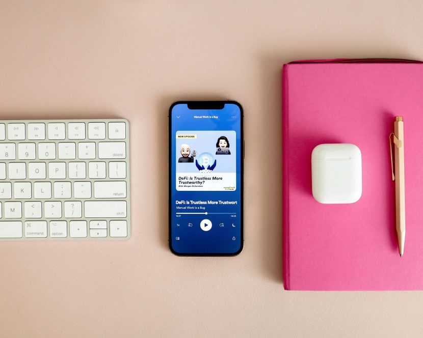 Smartphone playing one of the best motivational podcasts on a minimalist desk setup, creating a calm and inspiring atmosphere for mindful listening.
