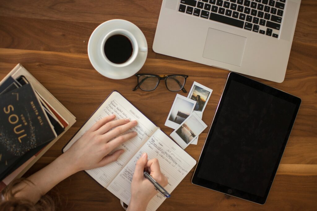 Workspace with notebook, tablet, laptop, and coffee illustrating digital detox benefits and healthier screen time habits for productivity and mindfulness.
