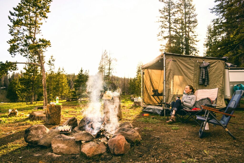 Camping in Turkey with a cozy forest campsite, campfire, outdoor tent setup, and peaceful nature atmosphere surrounded by pine trees.