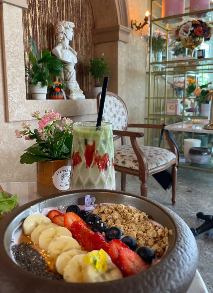 Breakfast in Antalya at Flower Bar with a colorful fruit bowl, granola, strawberries, blueberries and refreshing strawberry matcha.
